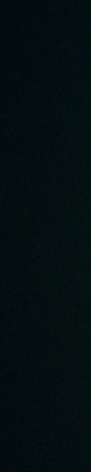 Vertical still — a hot blade of light splitting a dark room.